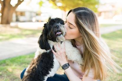 Une jeune femme faisant un baiser à un Shih Tzu
