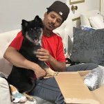 Un Husky Sibérien assis sur un canapé à côté d'un jeune homme