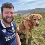 Un Labernois assis sur un terrain herbeux et portant un harnais