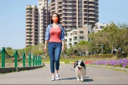 Un Border Collie tenu en laisse par une femme portant un cache-nez