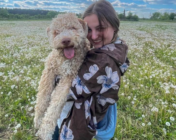 Un Lagotto Romagnolo  dans les bras d'une jeune fille