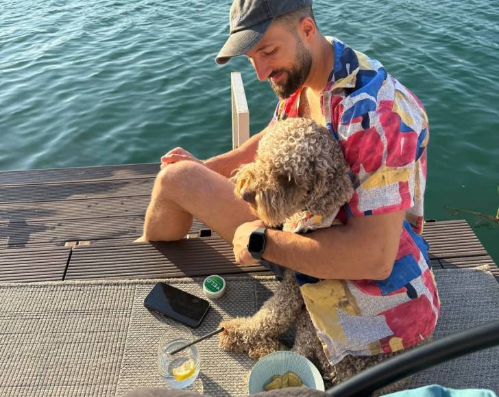 Un Lagotto Romagnolo assis à côté de son maître